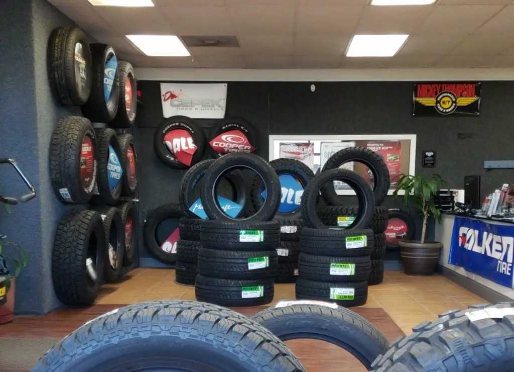 The tire brand wall inside Bailey's Tire Service showing Cooper, Mickey Thompson, Falken and stacked stock